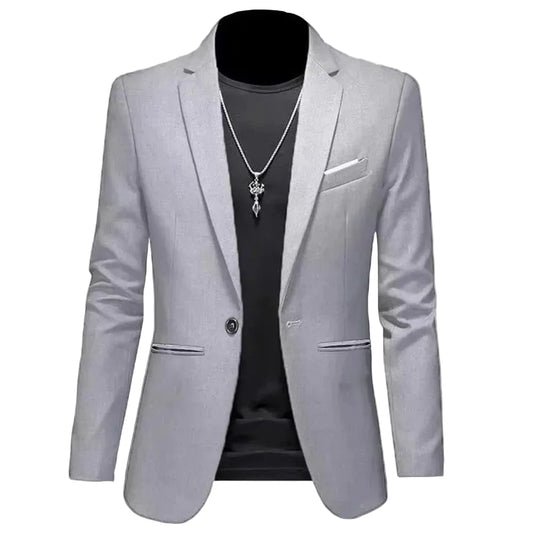 Gray blazer over a black shirt with a necklace on a gray background
