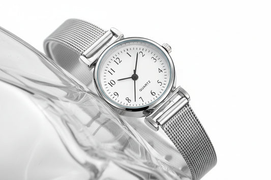 Silver watch with a white face on a textured surface